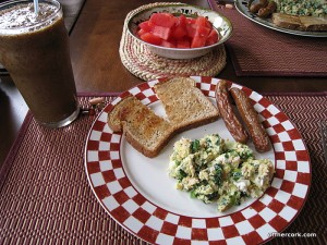 Smoothie, toast, eggs, sausage, and fruit 