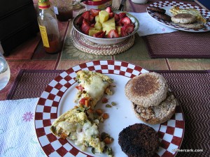 Eggs, english muffin, sausage, and fruit 
