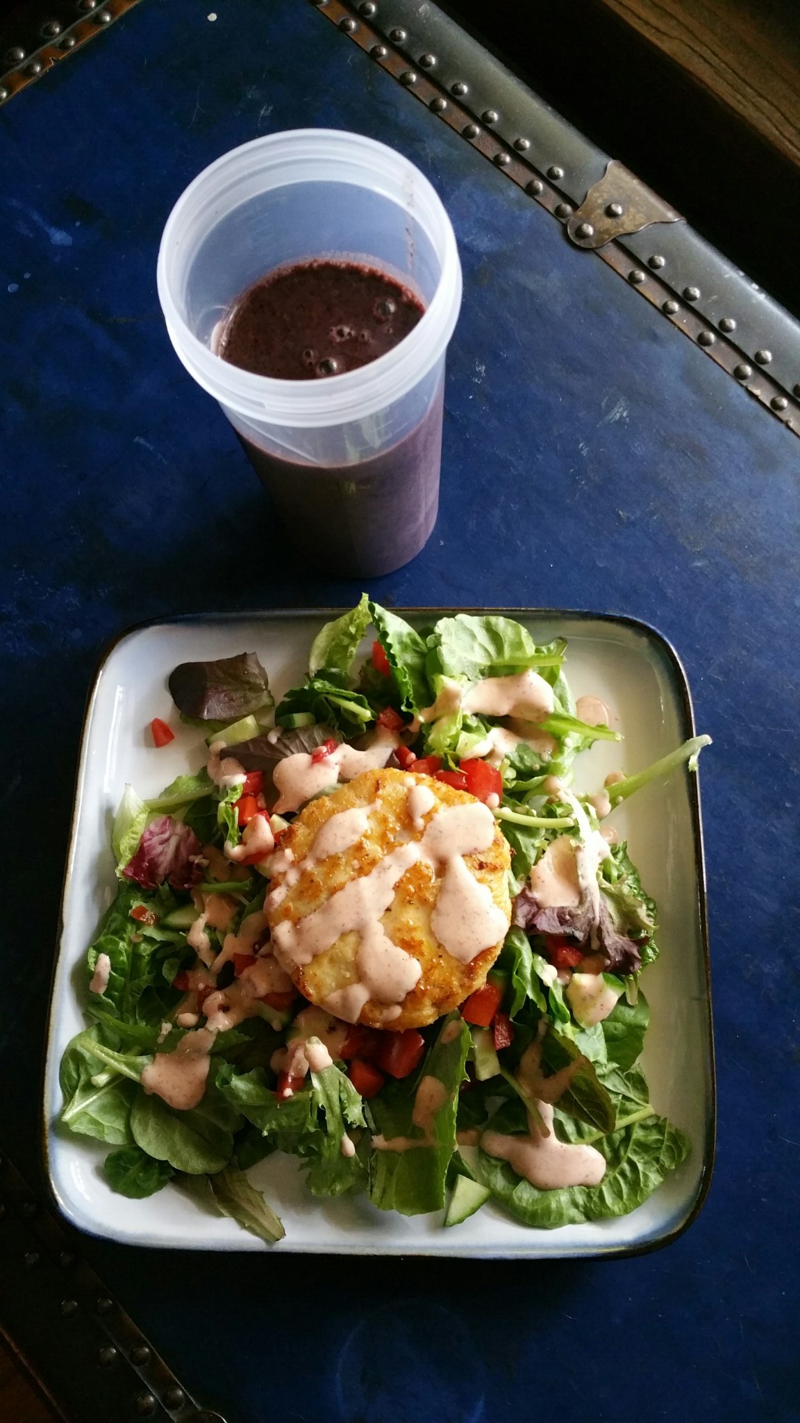 Salad with a mahi mahi burger and smoothie